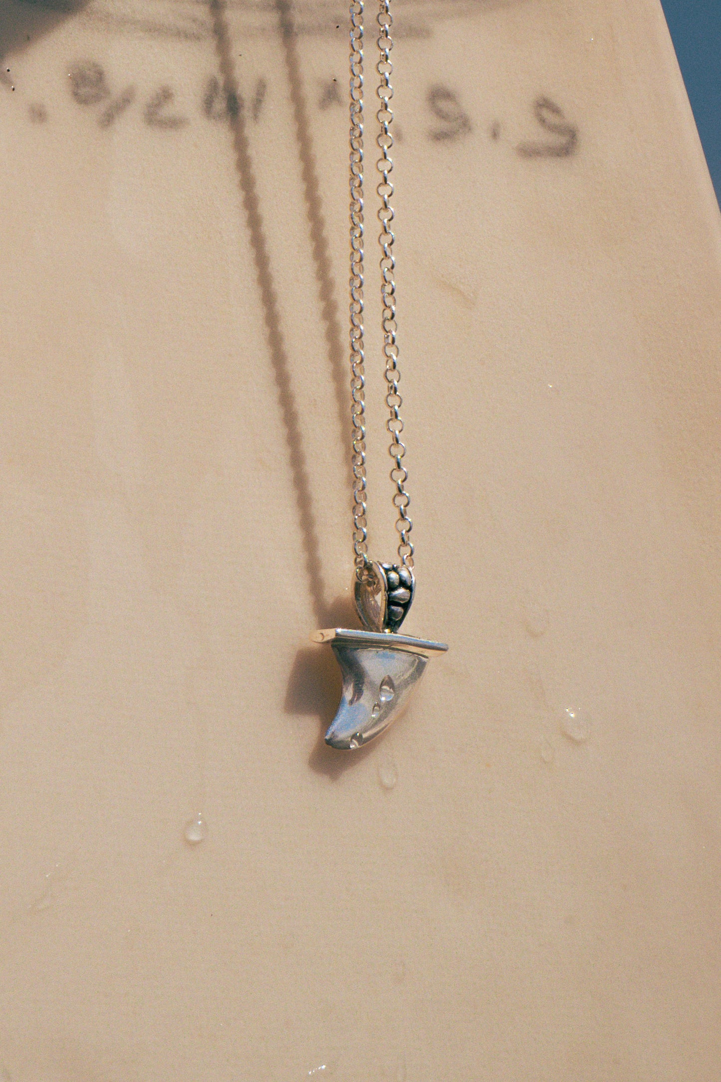 Necklace with a pendant on a beige surface