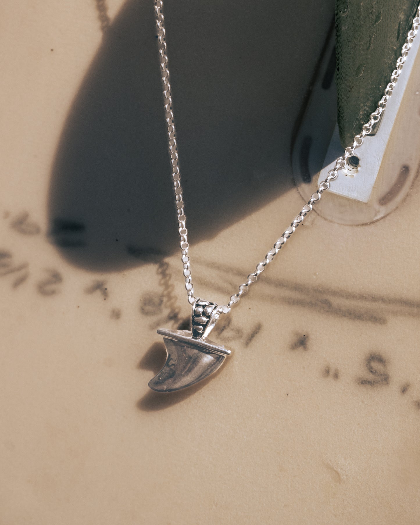 Silver necklace with a pendant on a textured surface