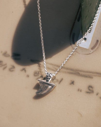 Silver necklace with a pendant on a textured surface