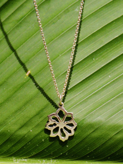 Daisy Pendant on a Sterling Silver Chain, Product Photo in front of a Banana leaf. 